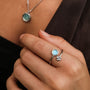 "Zendala Ring", a stylish silver ring with a nacre accent, paired with a matching necklace for a cohesive look.