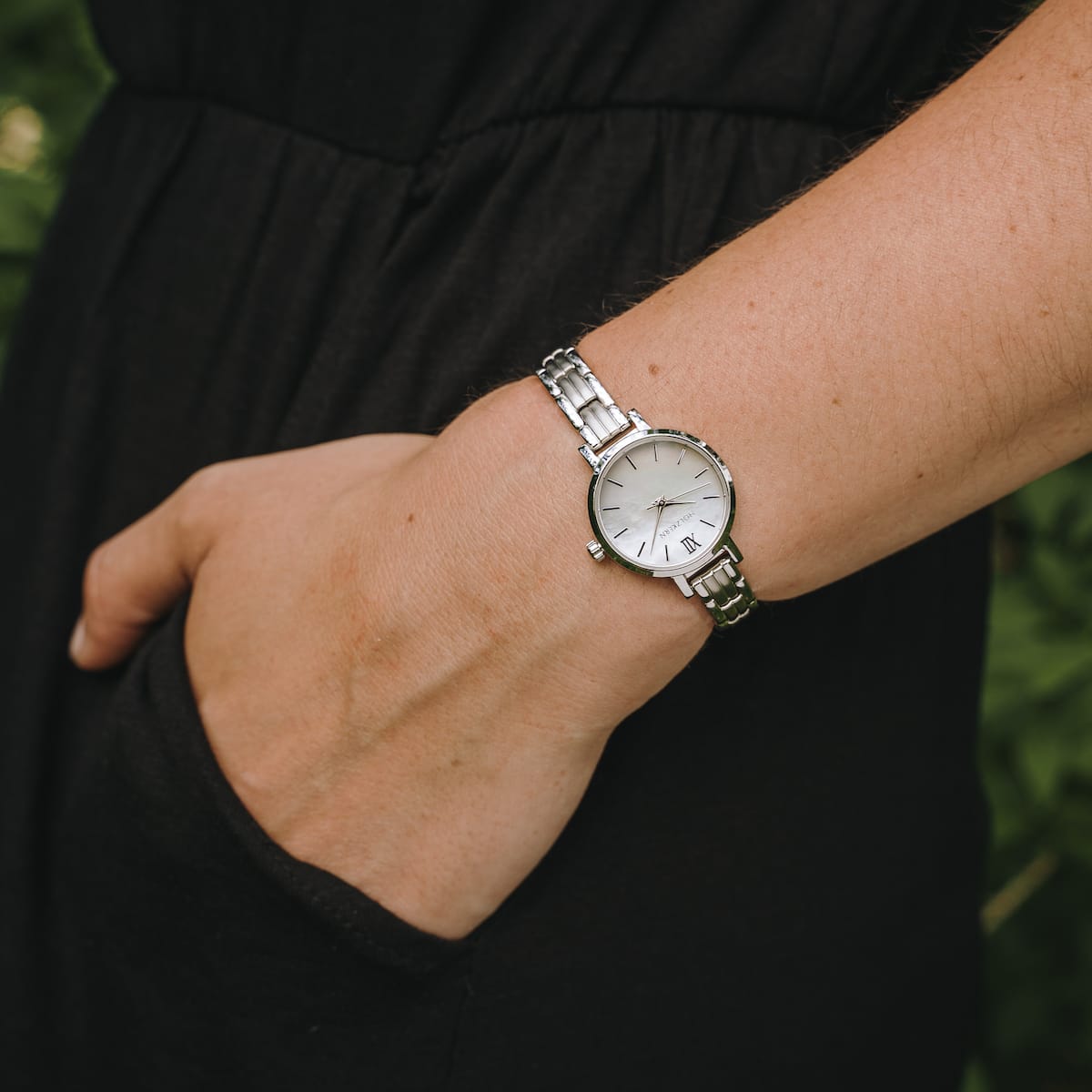 "Skadi", a sleek silver and nacre watch, elegantly worn on the wrist.