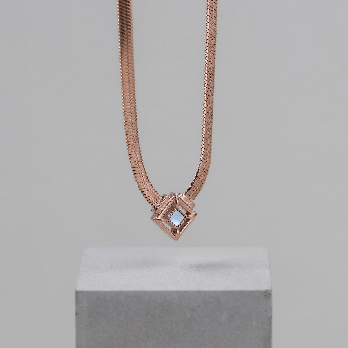 "Collana in attesa", una collana in oro rosa con un design geometrico moderno.