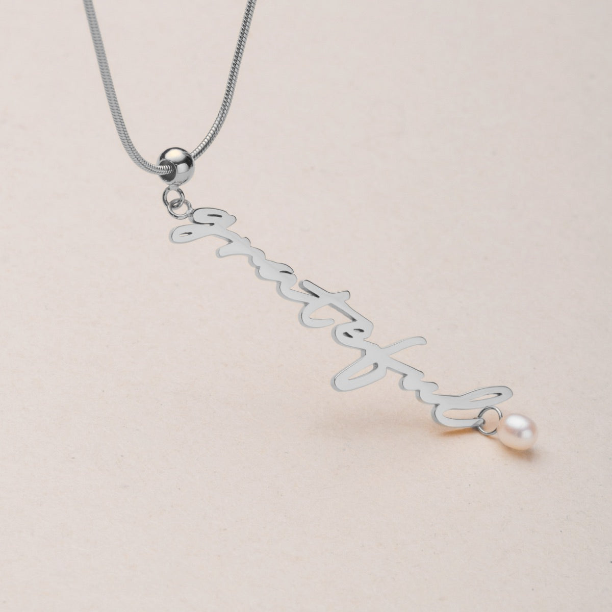 Collana "Grateful-Charm" con un design di scrittura argento e accento perla.