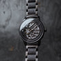 Orologio "Carbon", caratterizzato da un acero grigio e grigio scuro, presenta un design elegante e moderno con dettagli intricati.