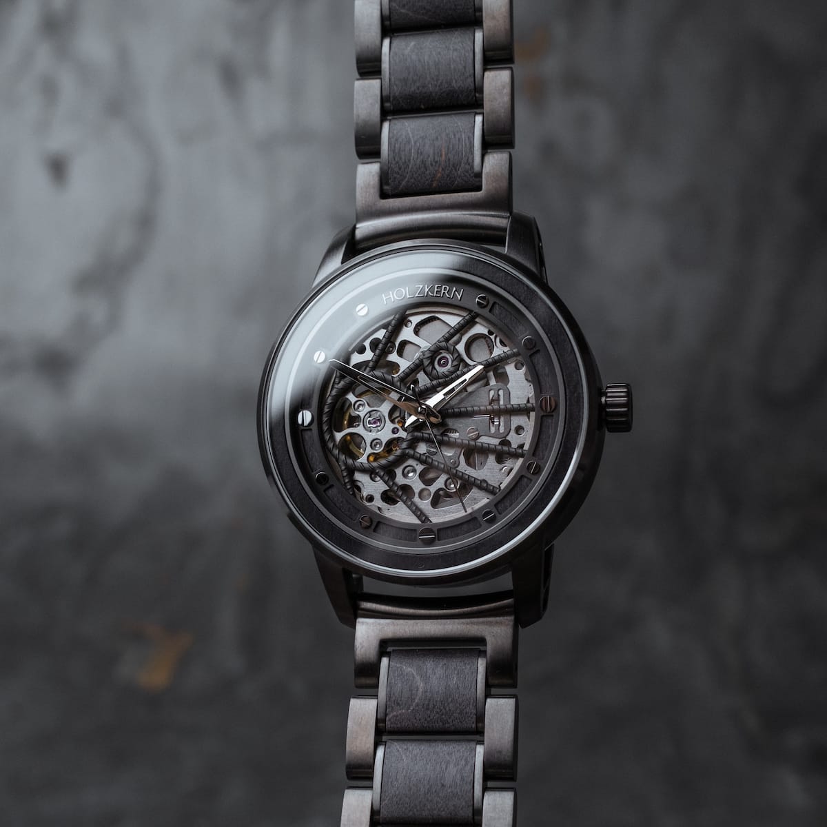 Orologio "Carbon", caratterizzato da un acero grigio e grigio scuro, presenta un design elegante e moderno con dettagli intricati.