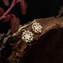 Elegant "Composition Gem Earrings" earrings featuring moonstone and gold with a delicate, intricate design against a dark background.