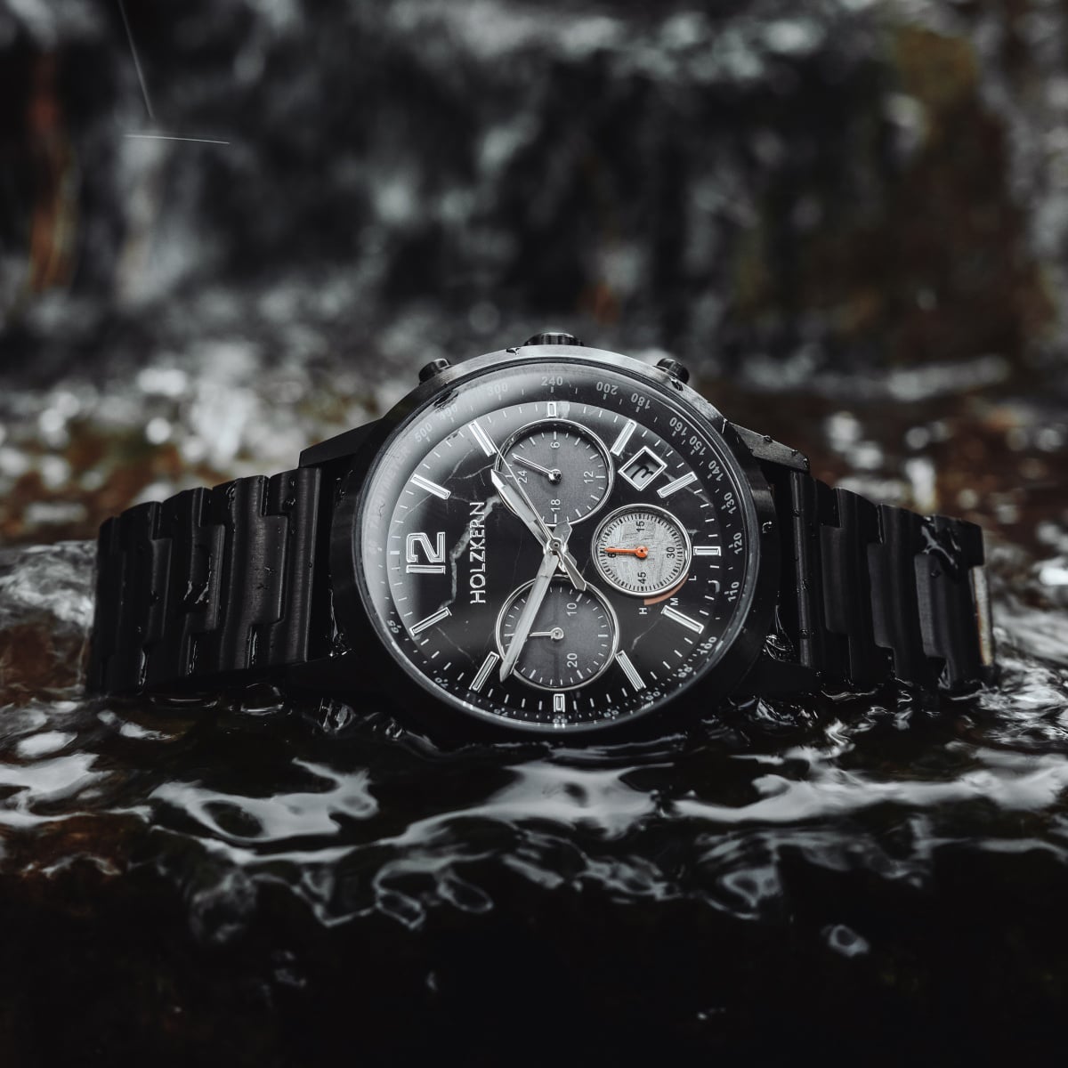 "Rahotu" watch with marble and black accents, featuring a bold, sleek design in a natural setting.