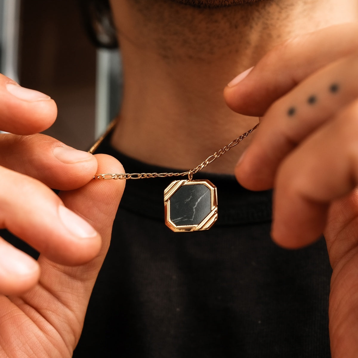 Collana "Scalar Collana" presenta un design in marmo con una catena in oro in una controparte geometrica elegante.