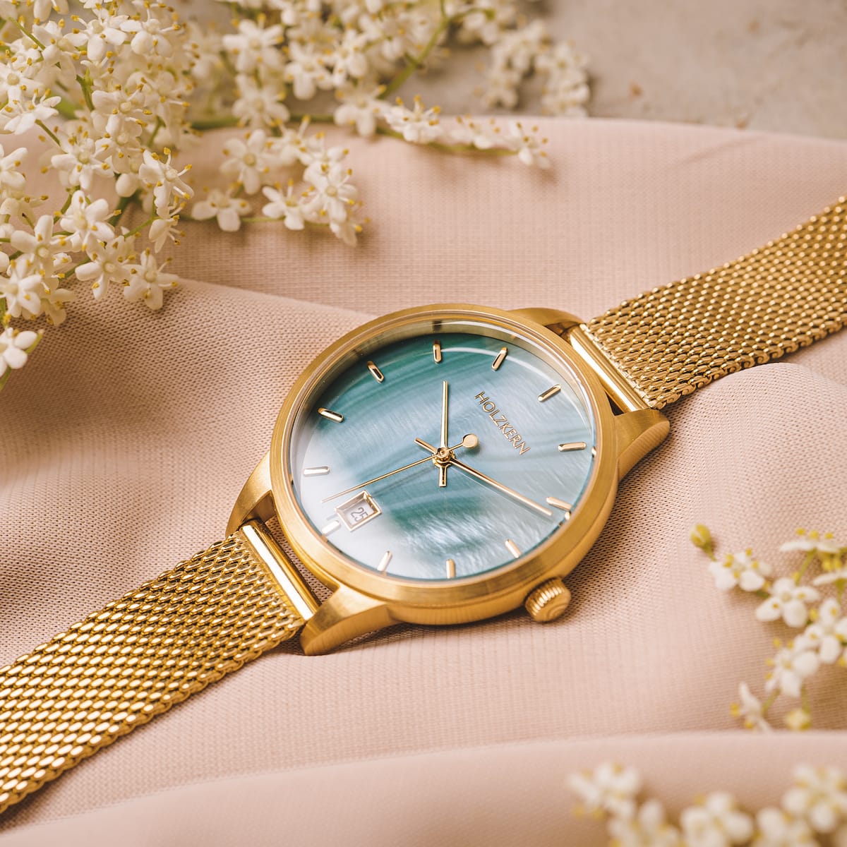 Orologio "Talamanca" con quadrante nacre e fascia in rete oro, design elegante e sofisticato.