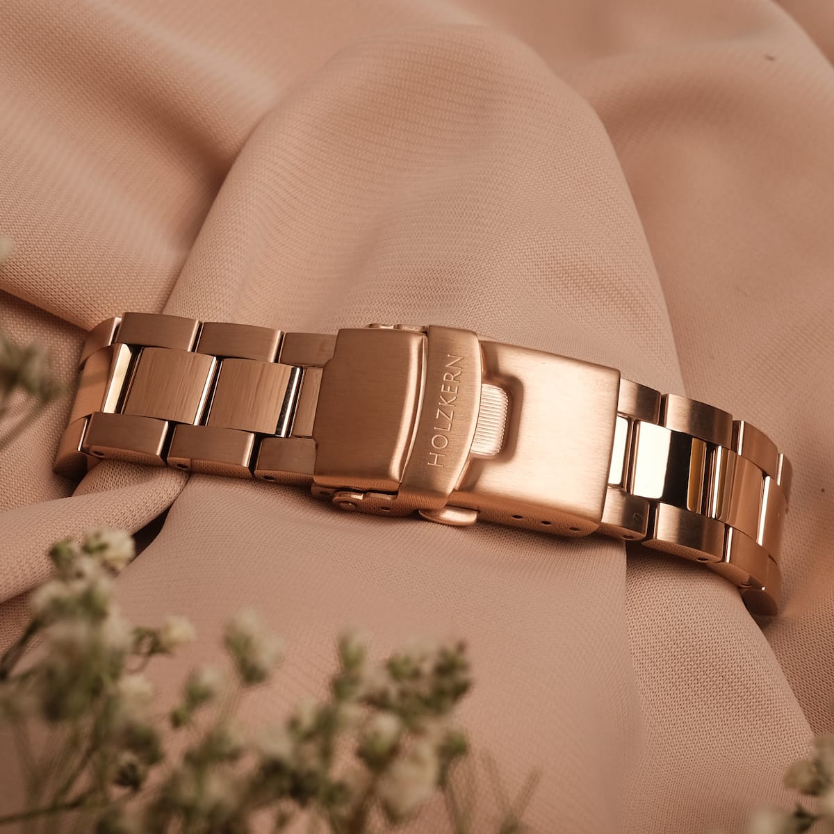 "The Passionate, elegant watch with rose gold accents and nacre finish on soft fabric."