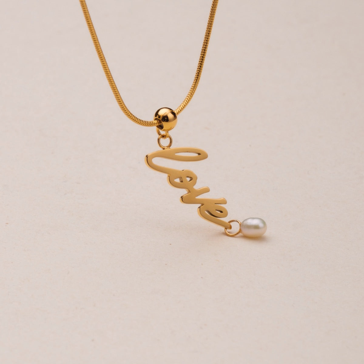 Collana "Love-Charm" con elegante catena d'oro e fascino d'amore con accento perla.