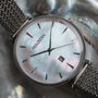 "Piccolo" watch with nacre dial and silver mesh strap, elegant and stylish design.