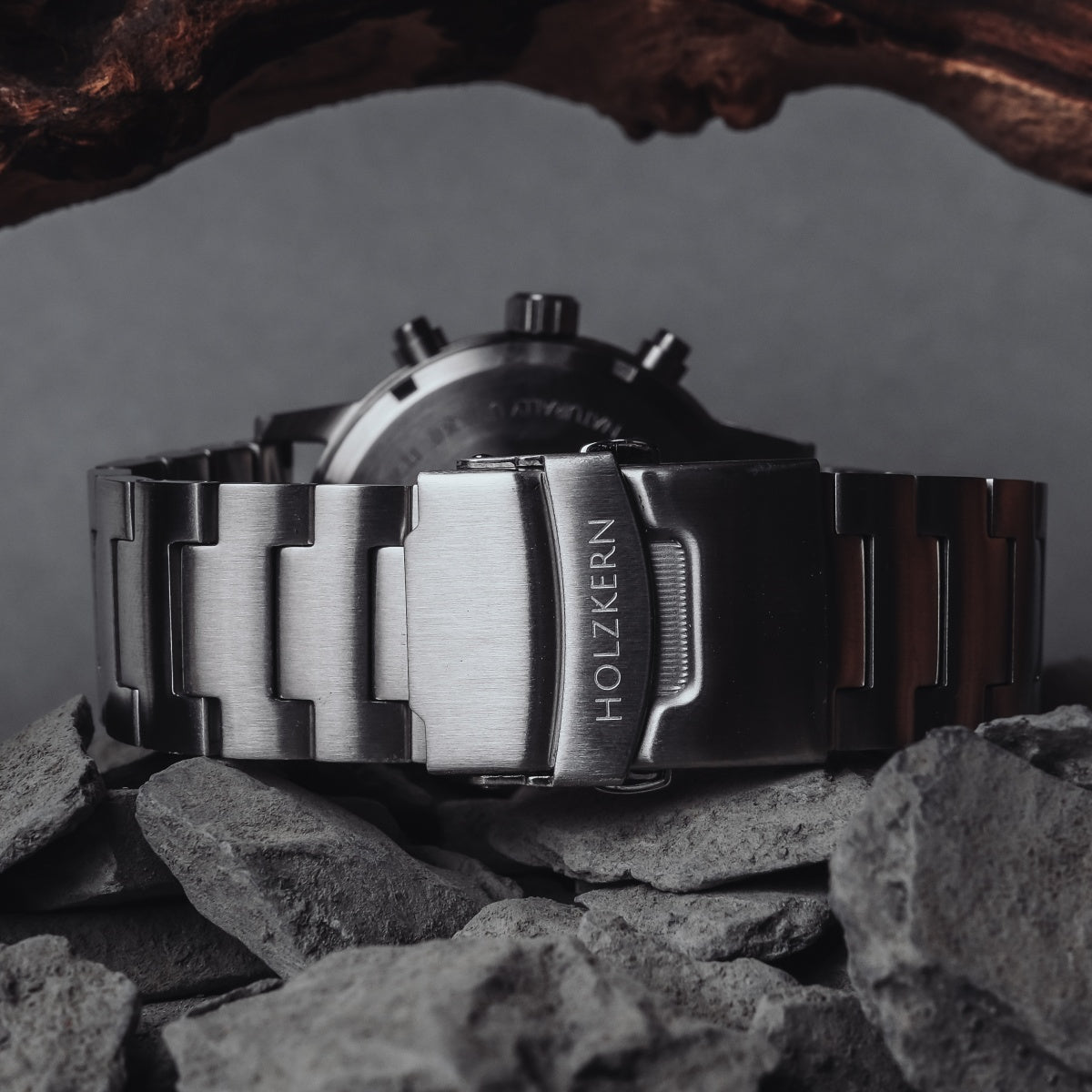 "Sagres" watch with sleek marble and silver design on a rugged stone backdrop.