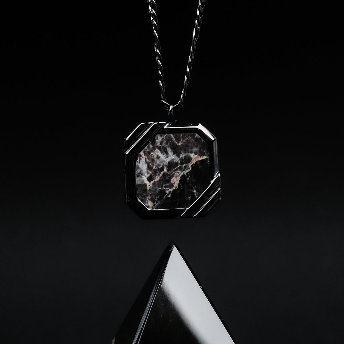 "Collana in pietra", una collana elegante con una pietra grigia scura dal design geometrico.