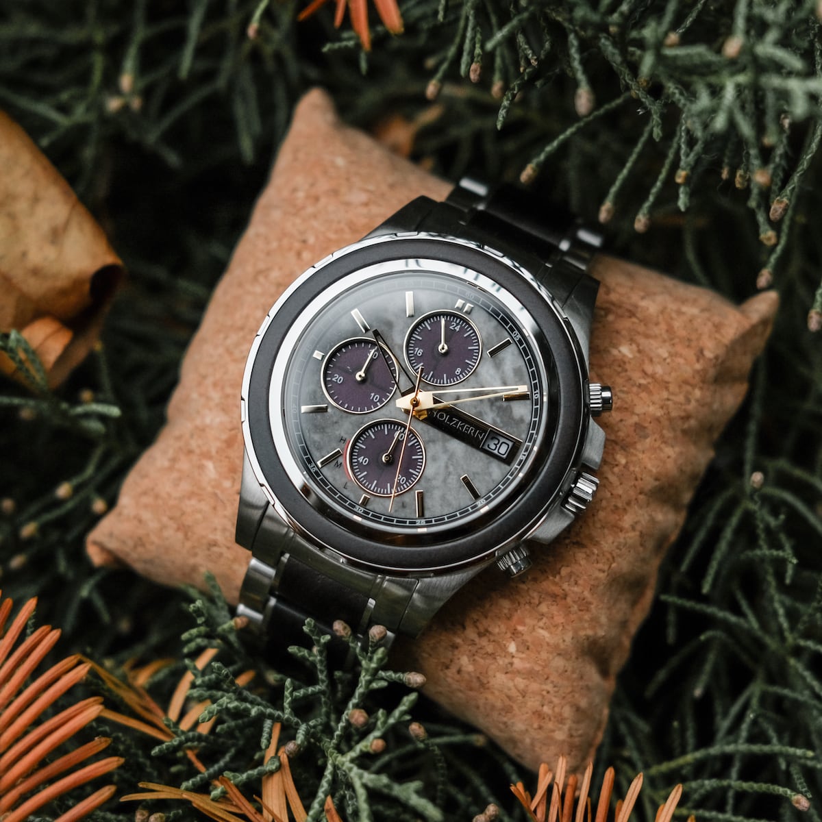 Orologio "Cairo" con un sofisticato disegno acero e marmo, ambientato su uno sfondo verde naturale.