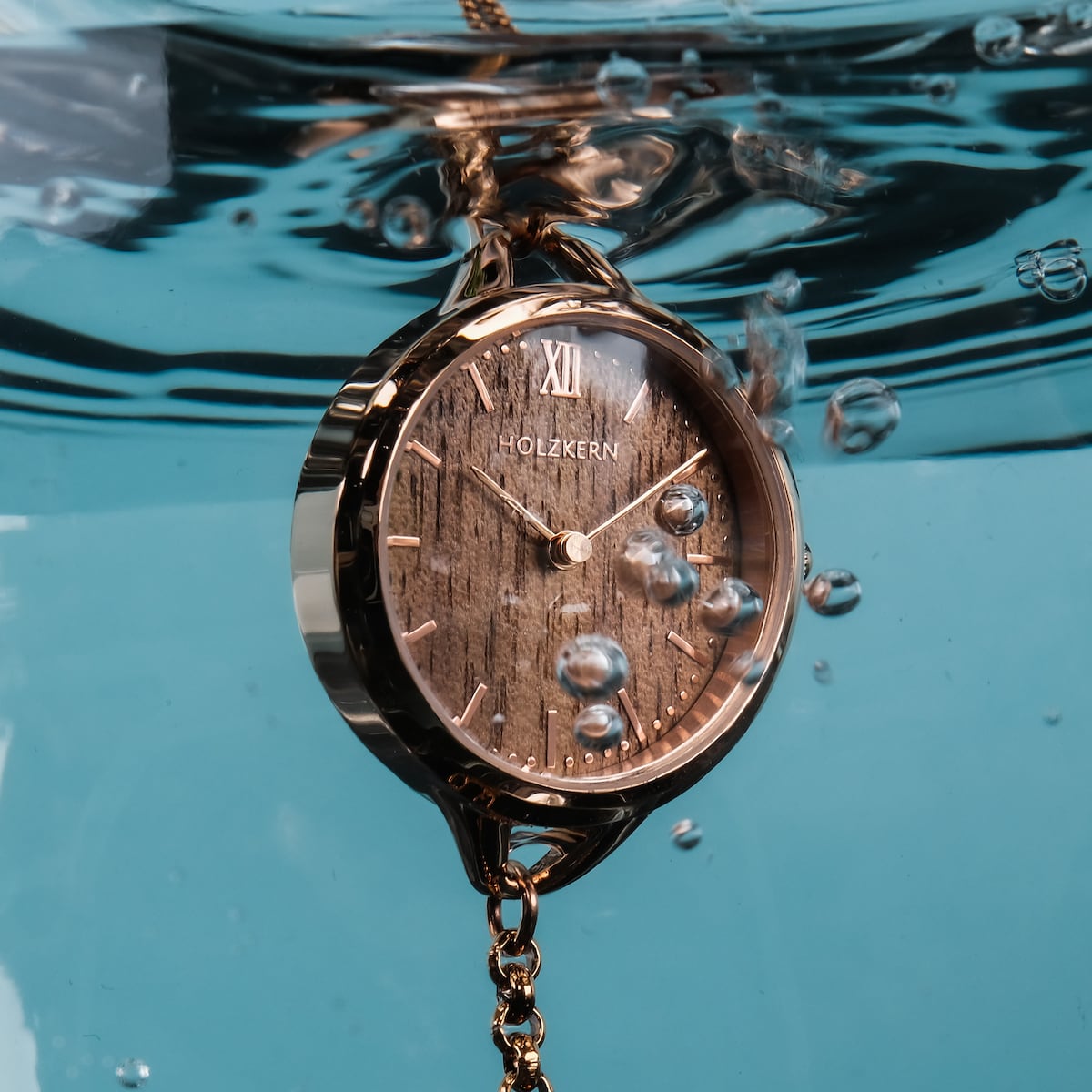 L'orologio "Blissed" presenta un volto in noce e accenti in oro rosa, catturati elegantemente sott'acqua.