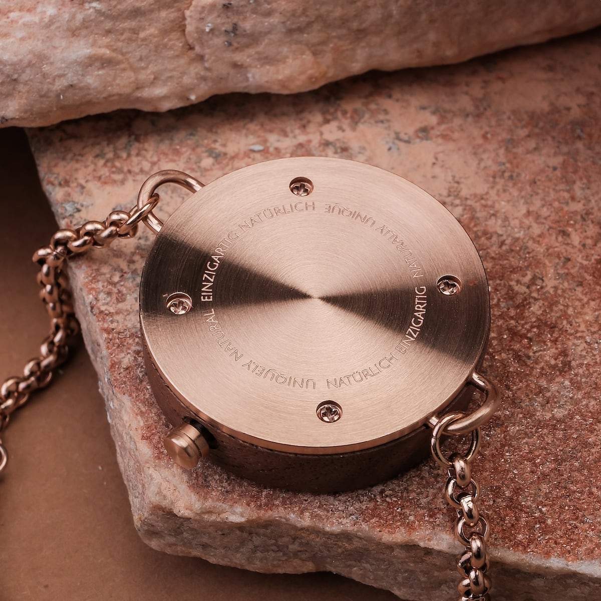 "Leave", un accessorio circolare in stile in una raffinata finitura in noce, con dettagli intricati in catena metallica.
