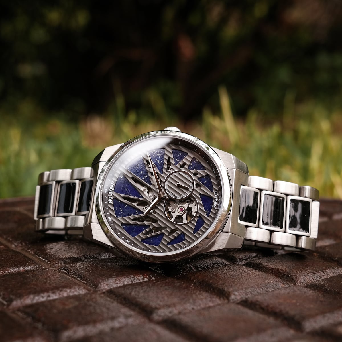 "Spikes watch with intricate design, featuring Lapis Lazuli and Maple accents on a silver metal bracelet."