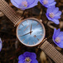 Orologio "Chitchat", con quadrante argentato e cinturino in mesh in oro rosa, in stile tra delicati fiori blu.