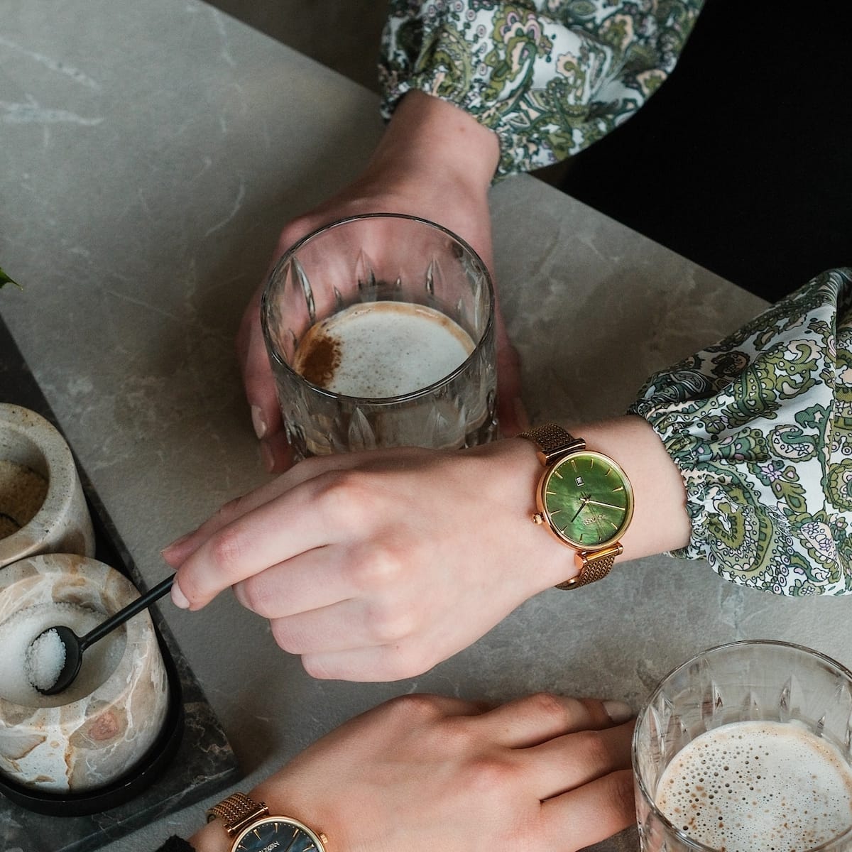 "Sunnyside" watch with a nacre and gold design, stylishly worn during a casual coffee moment.