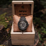 Orologio "Carbon" con quadrante a scheletro con acero grigio e accenti grigio scuro in una scatola di legno rustico.