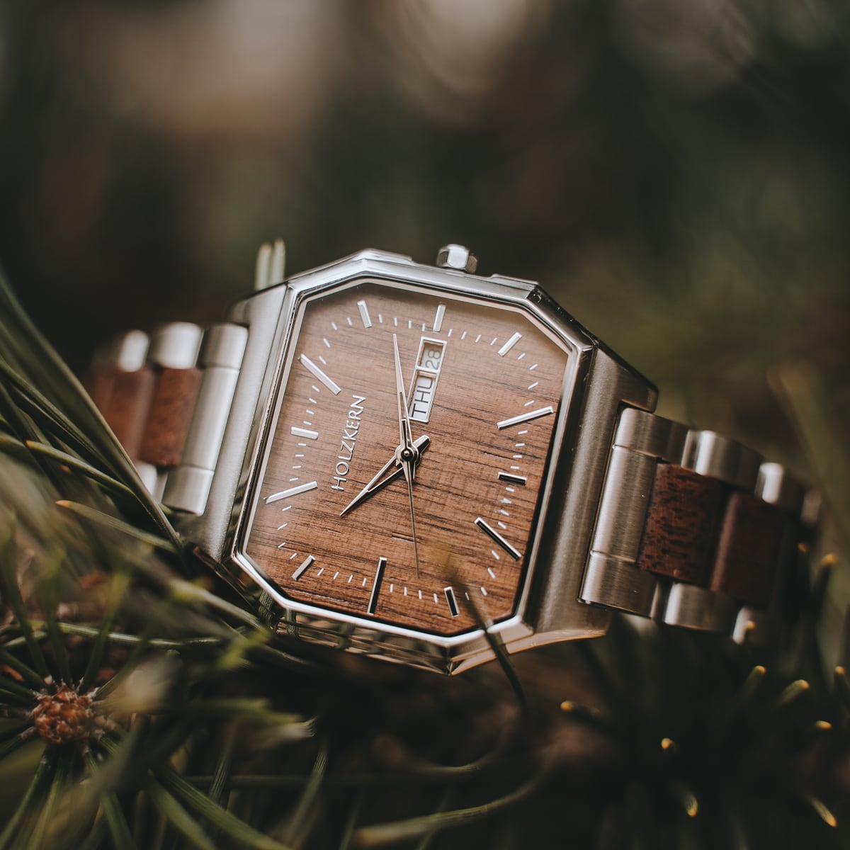 Orologio "Gaudí" con faccia in noce e accenti in acciaio inox, caratterizzato da un design moderno ed elegante.