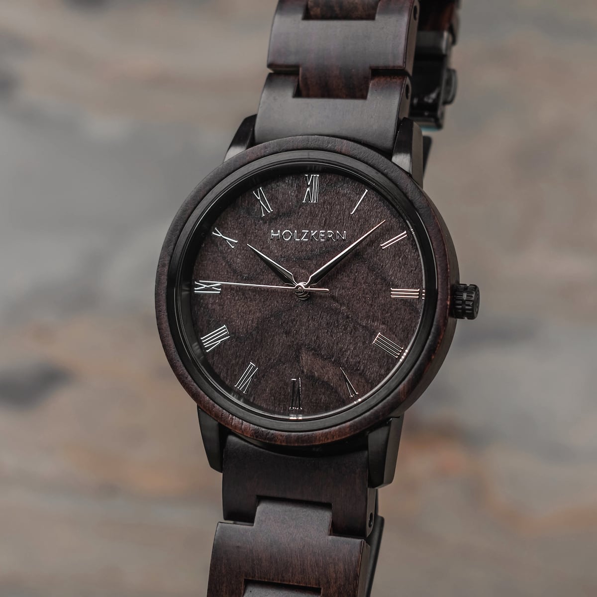 "Carlos" watch with a sleek maple design and minimalist Roman numerals on a dark wooden dial.