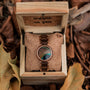 L'orologio "Ottimista" con legno di noce e quadrante in piuma pavone, elegantemente esposto in una scatola di legno rustico.