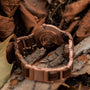 L'orologio "Ottimista", realizzato in noce con motivo in piuma di pavone, presenta un design elegante e naturale.
