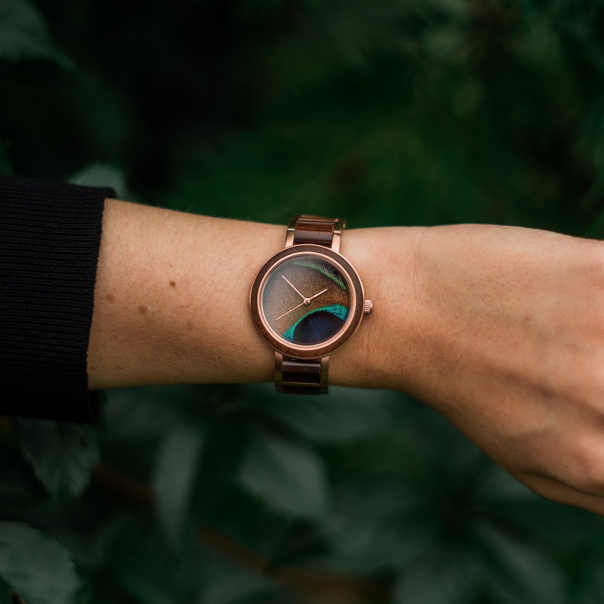 L'orologio "Ottimista" con bande in noce e design in piuma pavone, fondendo eleganza e natura.