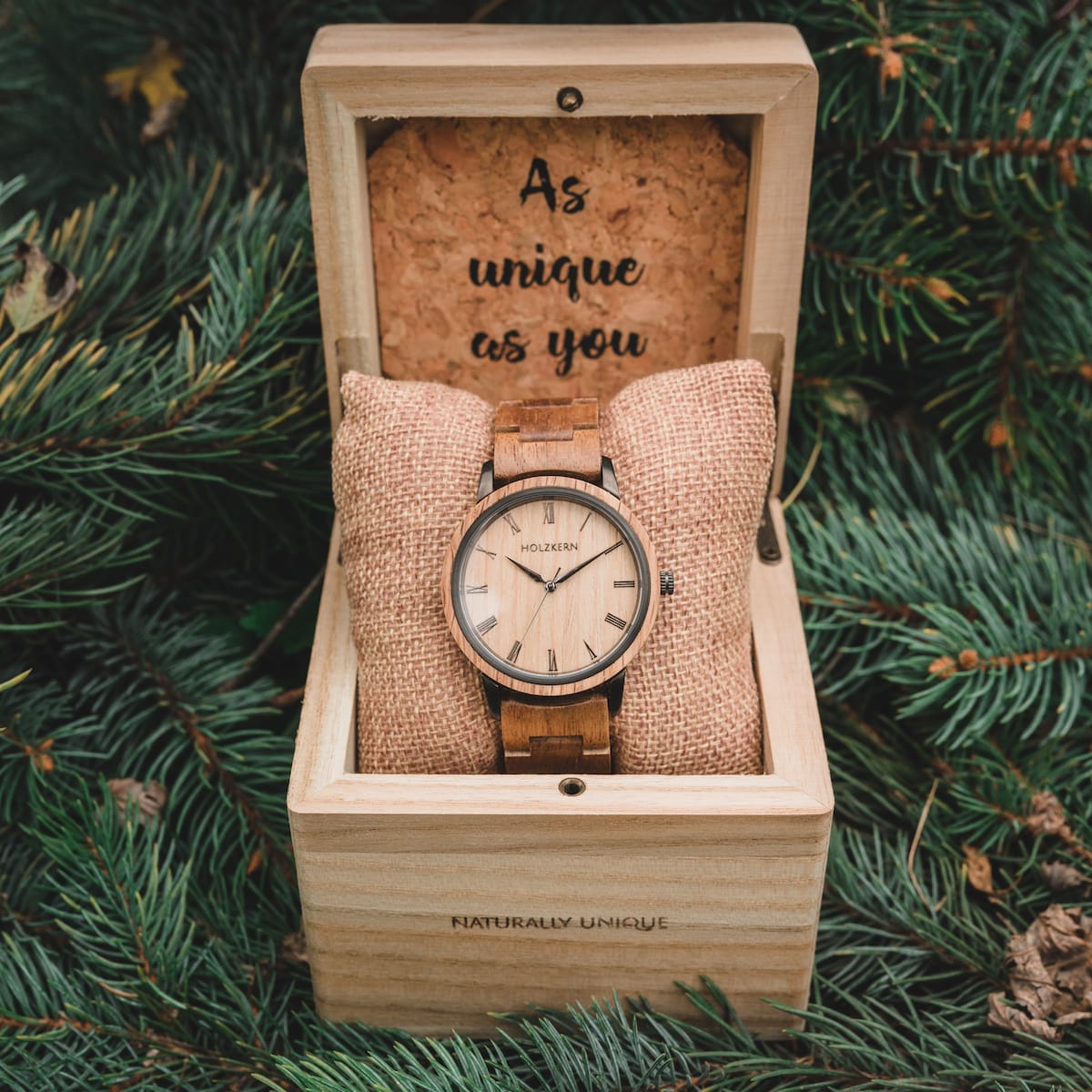 Orologio in legno "Taro", con un design elegante in rovere, esposto in una scatola in legno naturale con cuscino.