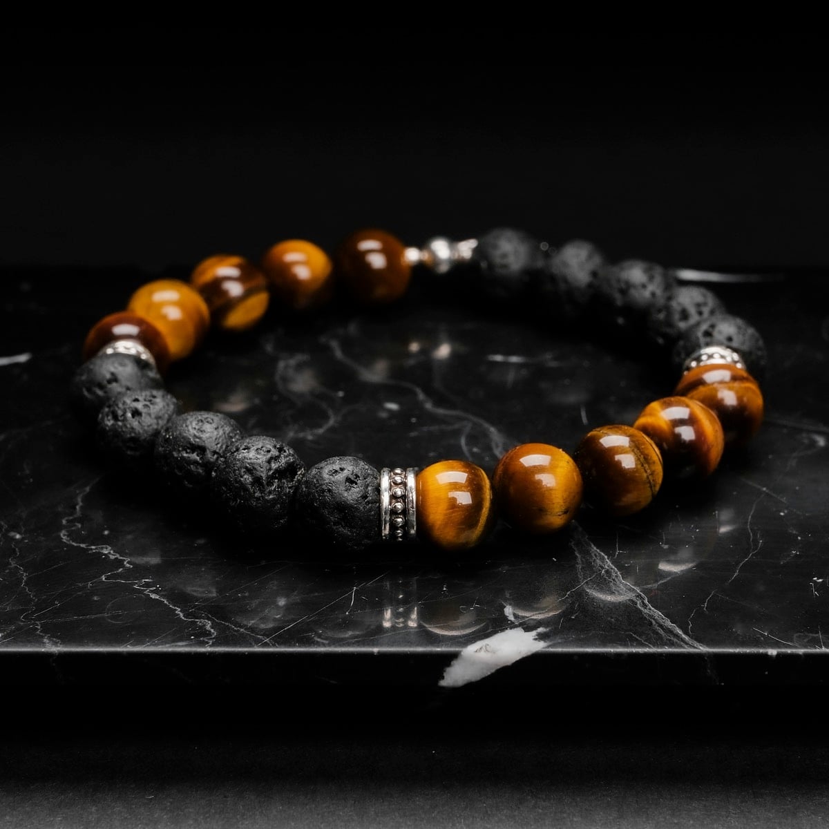 Bracciale "Superset" con pietre Tiger Eye e Lava su uno sfondo elegante e scuro.