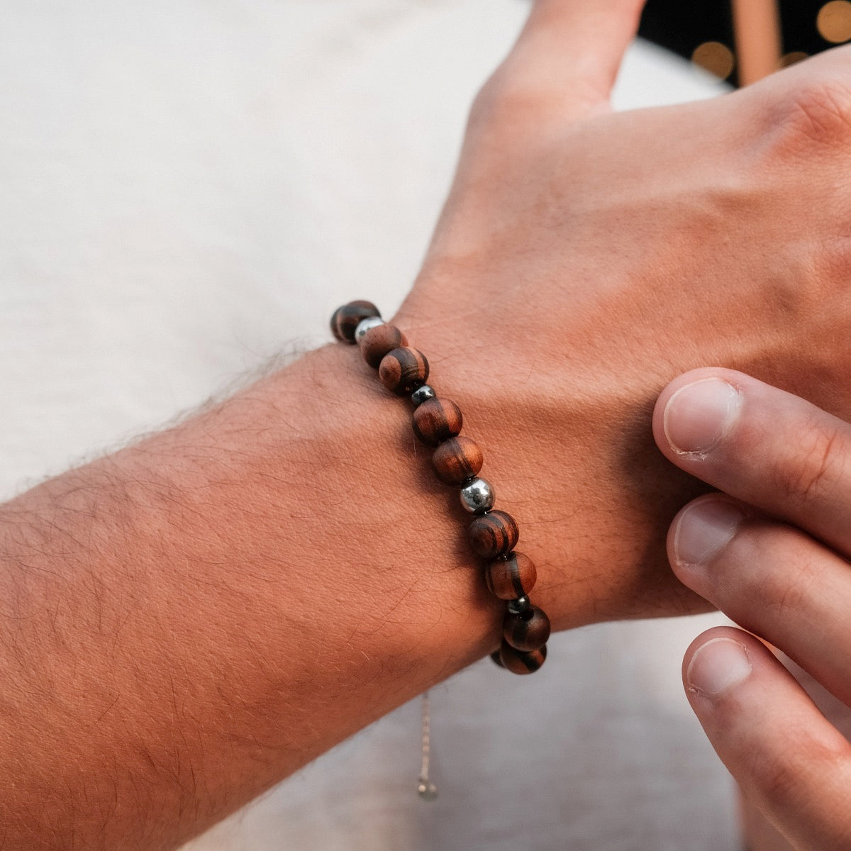 "Superset" bracelet featuring hematite and walnut beads, showcasing a natural and stylish design on a wrist.
