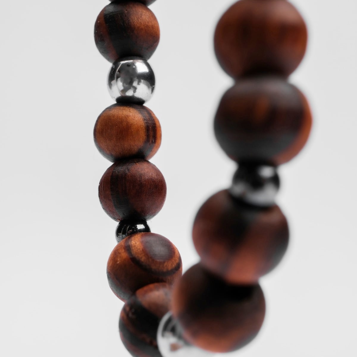 Bracciale "Superset" con perline di ematite e noce in uno stile moderno e terreno.