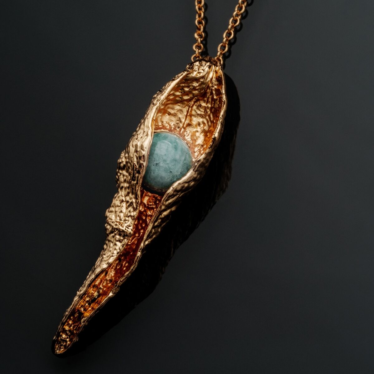 "Chalice Necklace", an elegant necklace featuring a gold chalice design with a striking amazonite stone.