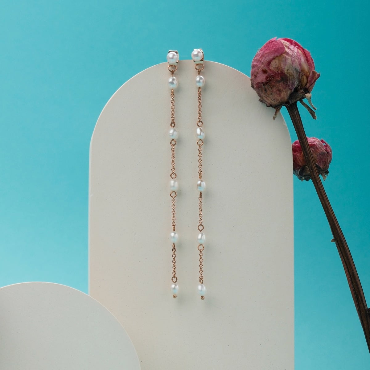 "Summersweet Orecchini II": Eleganti orecchini in oro rosa adornati di perle, in stile su uno sfondo vibrante.