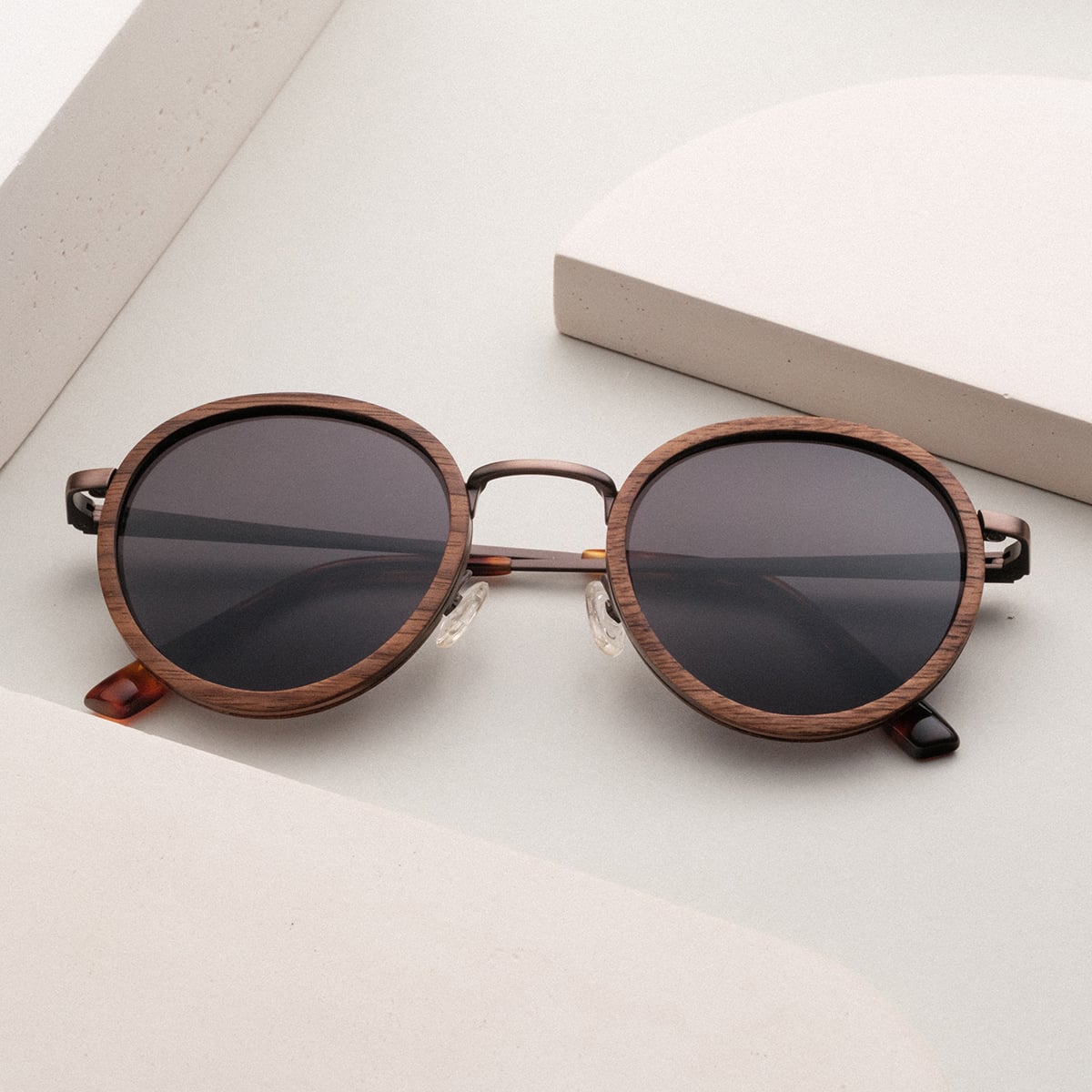"The Radiant S", stylish sunglasses with a walnut and copper finish featuring round lenses and a minimalist design.