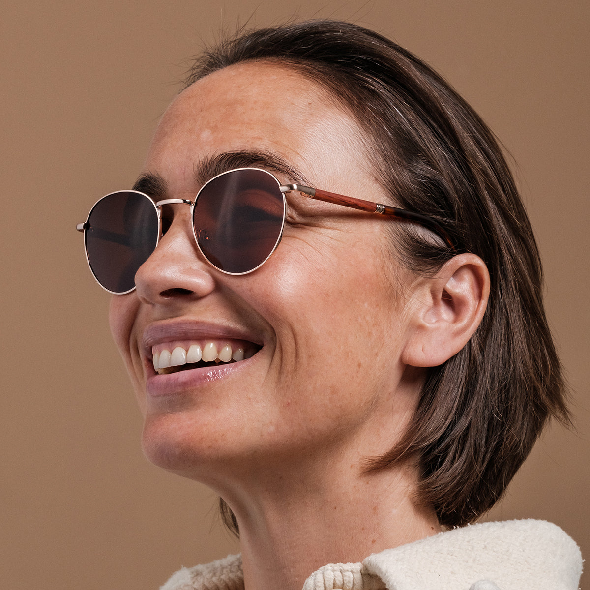 "The Achiever" sunglasses feature a padauk frame and matte gold accents, showcasing a stylish modern design.