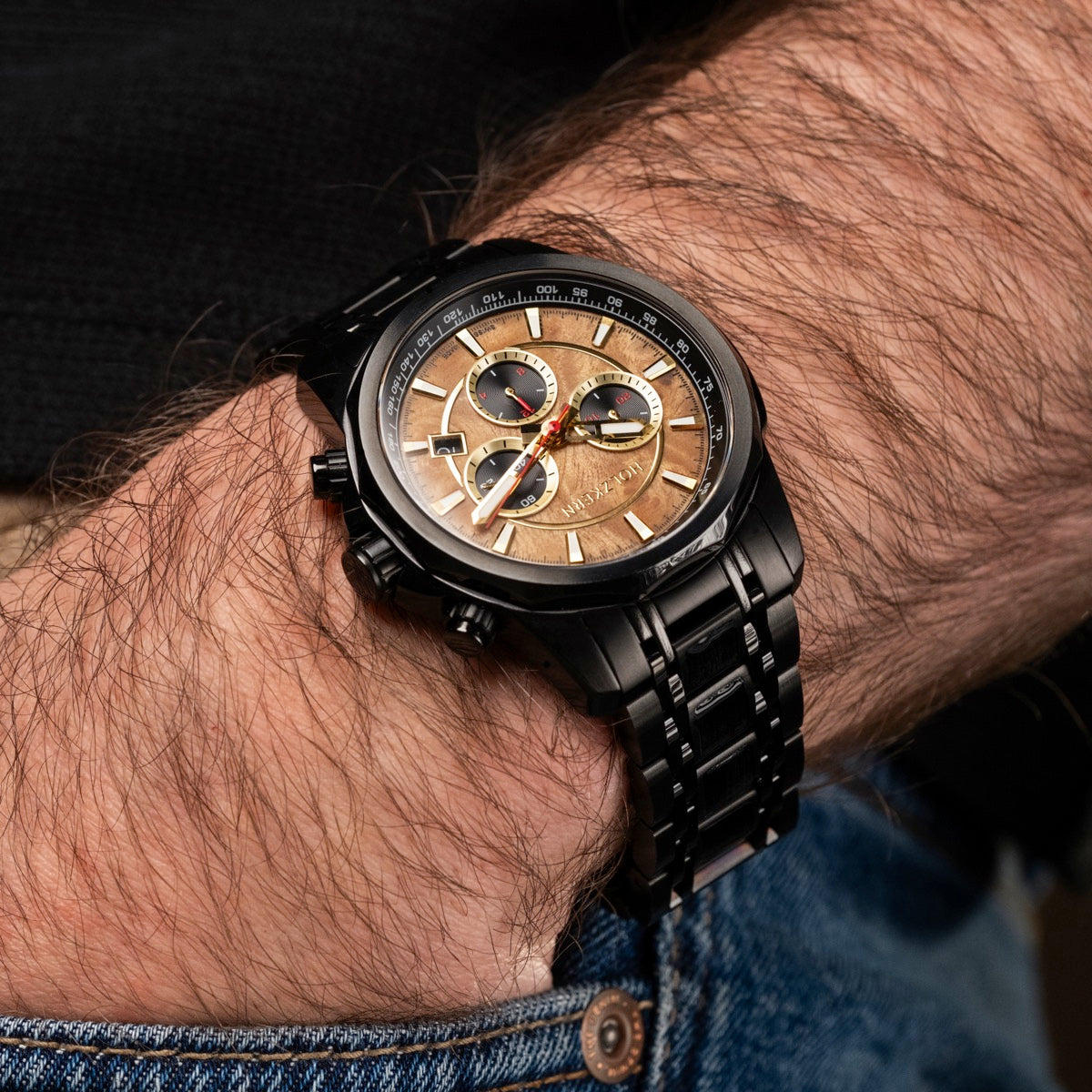 "Genevra watch with burl wood and maple accents features a sleek black metal bracelet on a wrist."