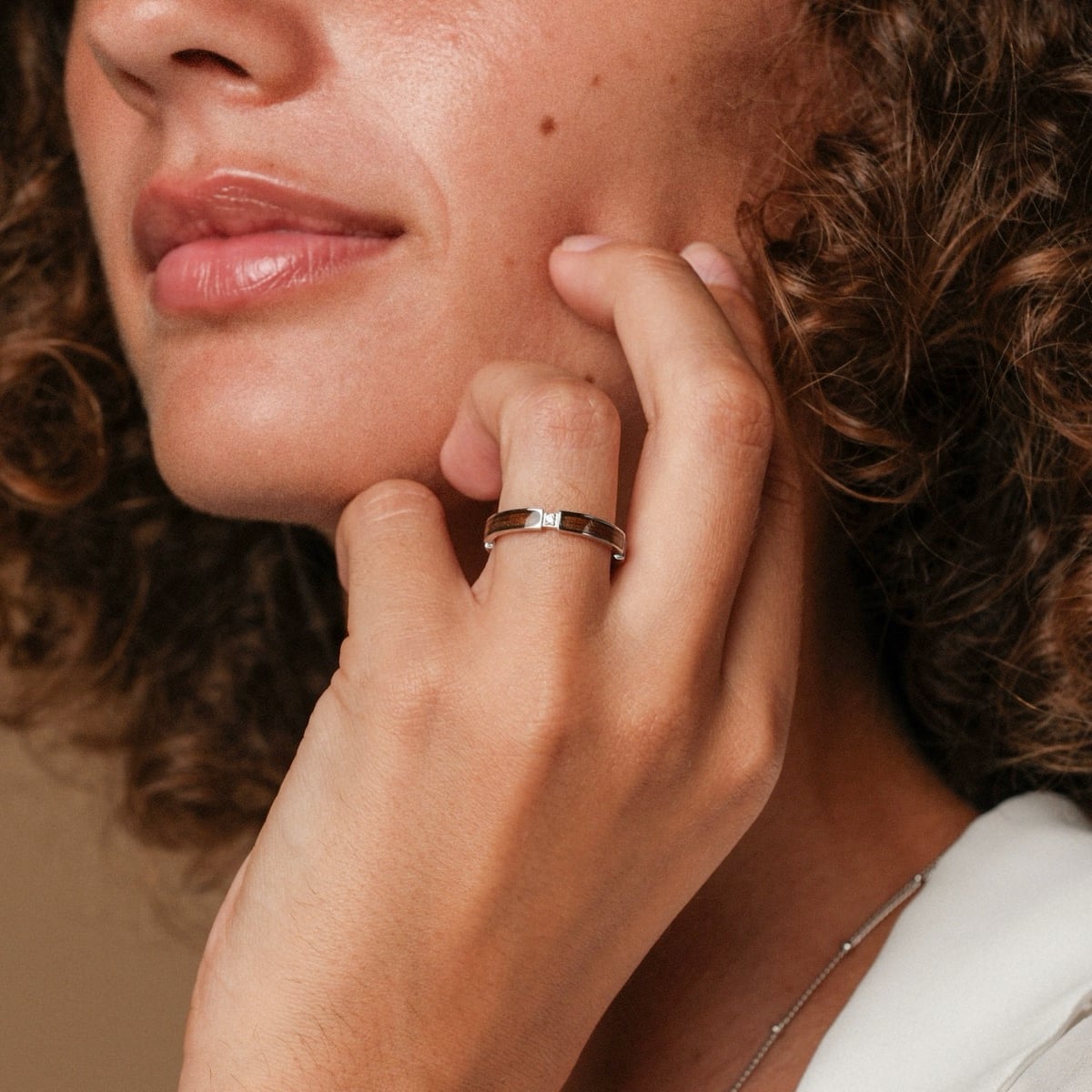 "Campania Ring II", a stylish ring crafted from walnut and silver, worn elegantly on a woman's hand.