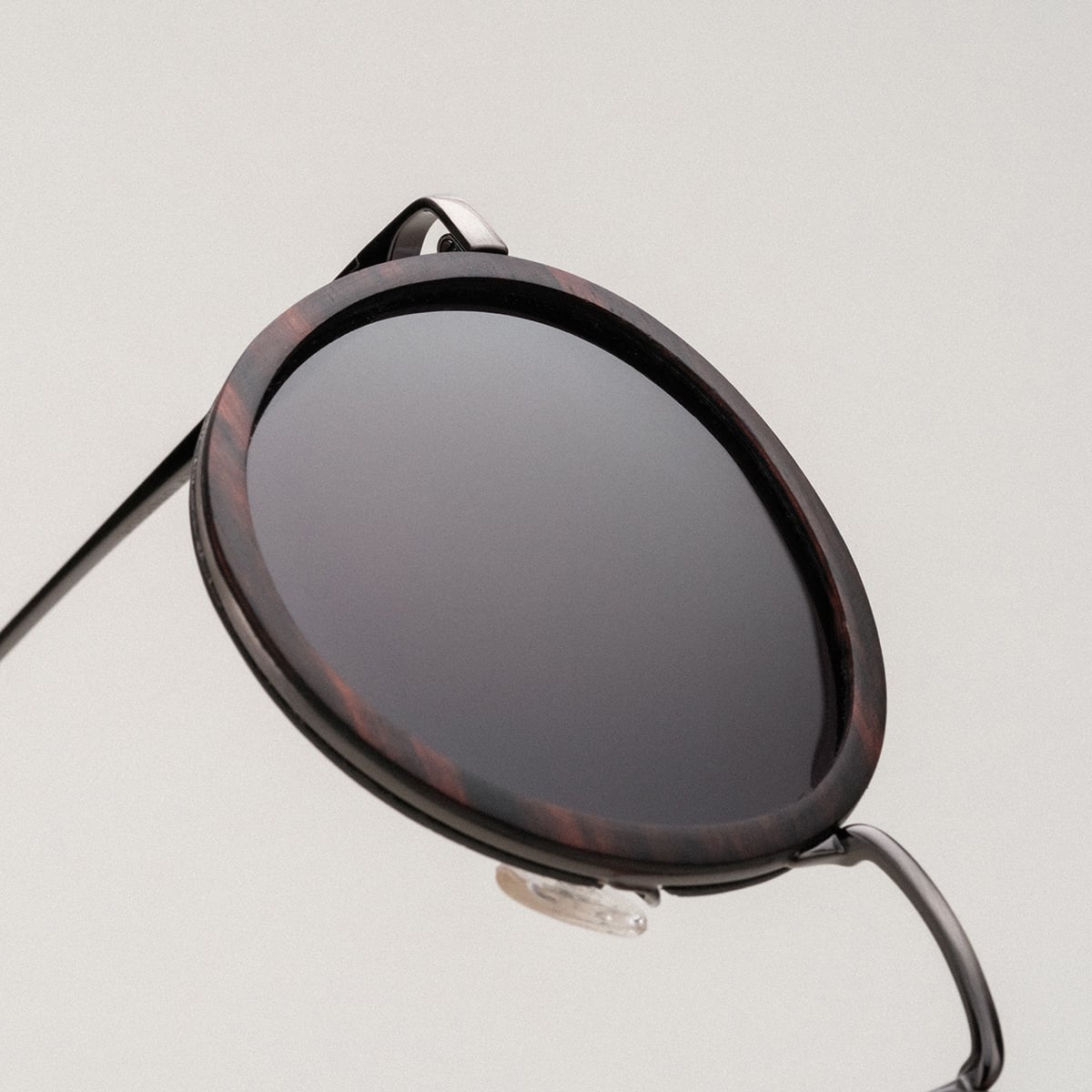 Occhiali da sole "The Radiant M" con cornice in legno di piombo e accenti d'argento antico per un look senza tempo e sofisticato.