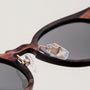 Occhiali da sole "The Maverick" con struttura in legno Padouk con accenti in rame per un look elegante e sofisticato.