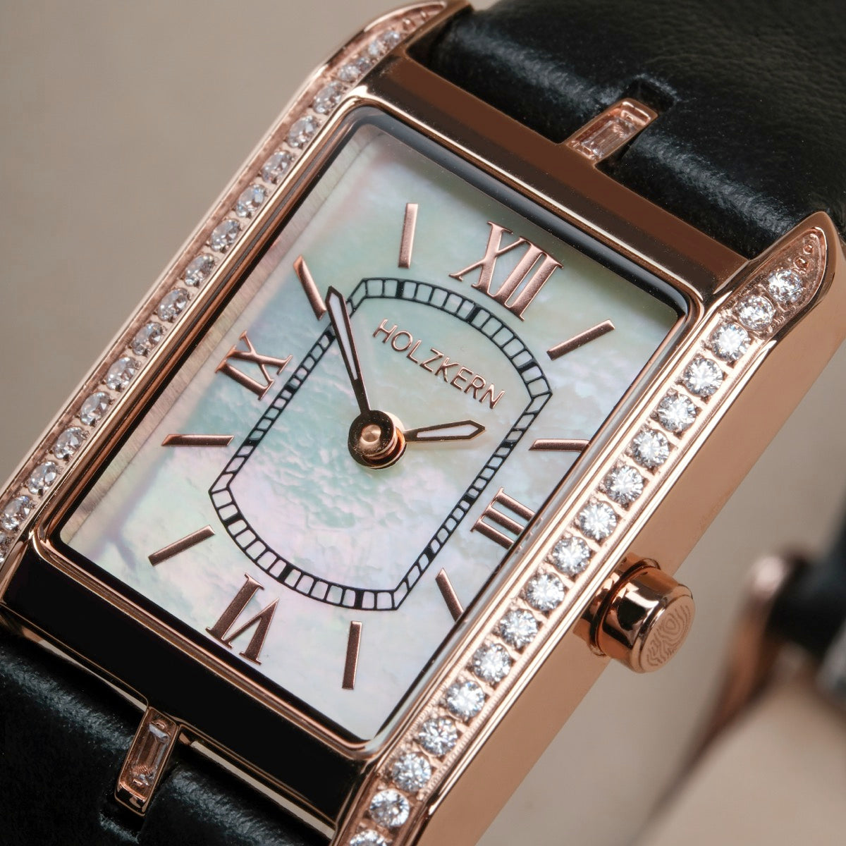 "Memoire", elegante orologio con faccia anacre e cinturino nero, con accenti in oro rosa e pietre scintillanti.