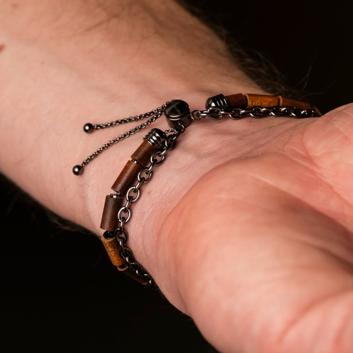 Bracciale "Supersonic" con una miscela unica di elementi in legno di koa e metallo grigio su un polso.