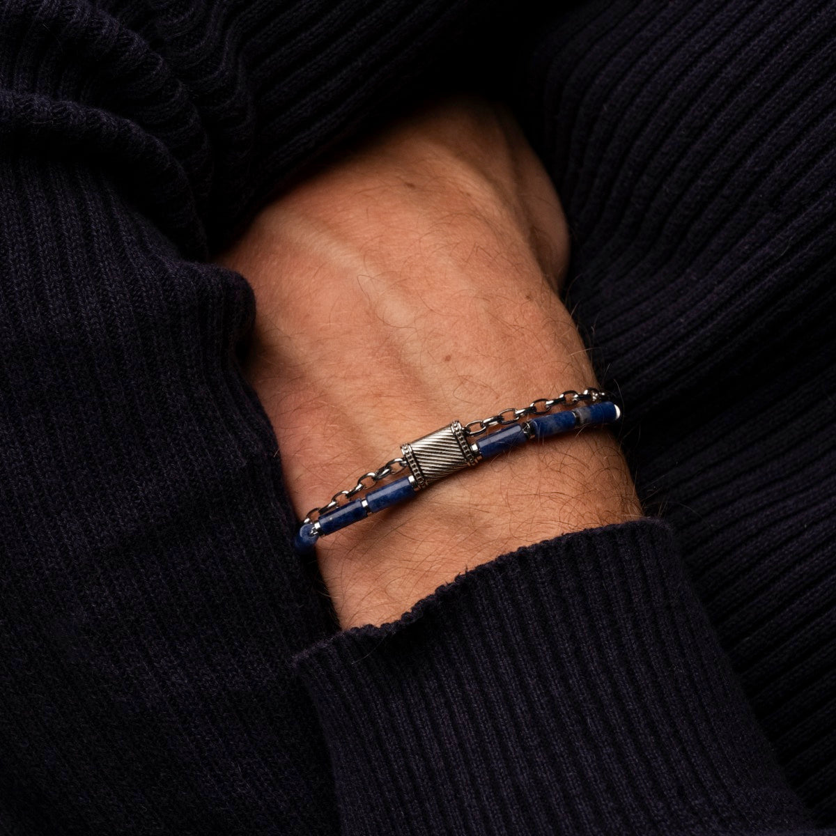 "Supersonic", a stylish bracelet with a marble and silver design, worn on a person's wrist.