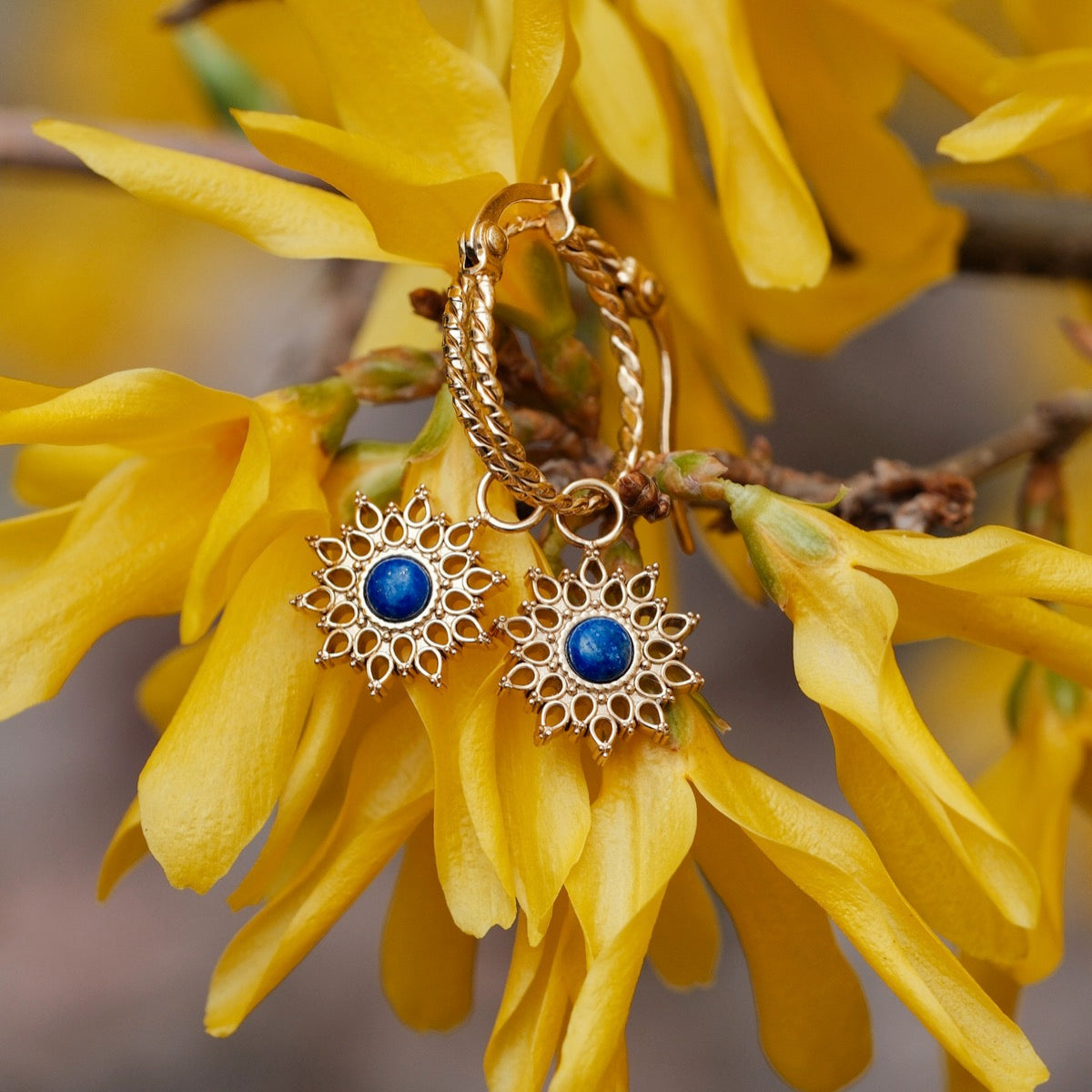 Orecchini Suncatcher con intricato disegno oro con lapis lazuli centro, in stile contro fiori giallo vibrante.