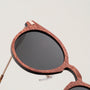 Gli occhiali da sole "The Maverick", caratterizzati da una struttura in legno Padouk e da accenti in rame, presentano un design elegante e unico.