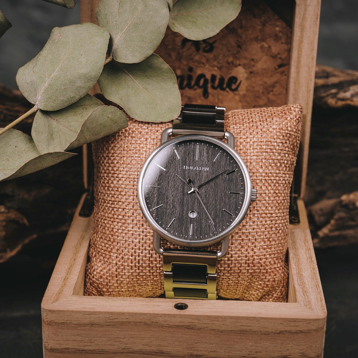Orologio "Odaiba" in una scatola di legno, con un viso scuro elegante con un design minimalista e accenti metallici.