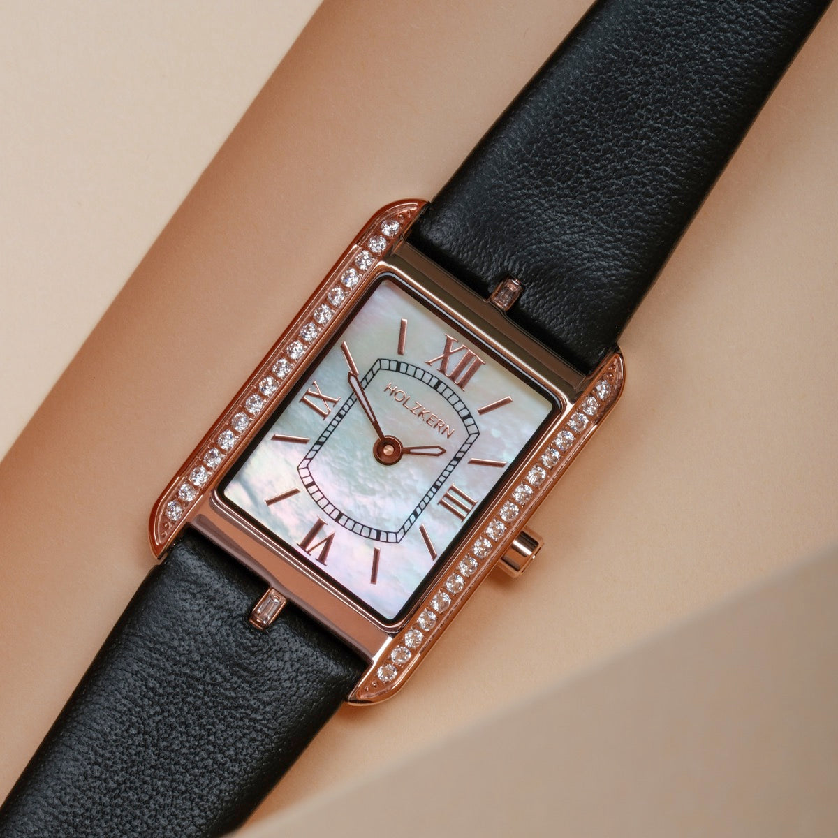 Orologio "Memoire" con un viso nacre, cinturino in pelle nera e eleganti accenti in oro rosa.