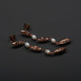 "Summersweet Earrings I elegant earrings featuring pearls and rose gold details on a sleek black background."
