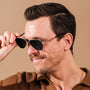 "The Badass I", eleganti occhiali da sole con finitura in noce e oro opaco, esaltando un look moderno e sofisticato.