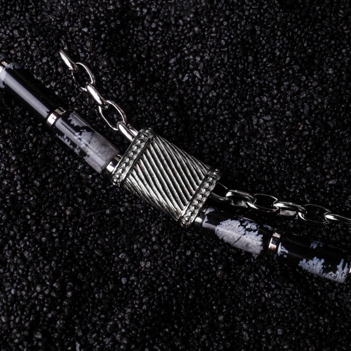 "Supersonic", un bracciale a catena elegante in ossidiana e argento, che mostra un design moderno e strutturato.