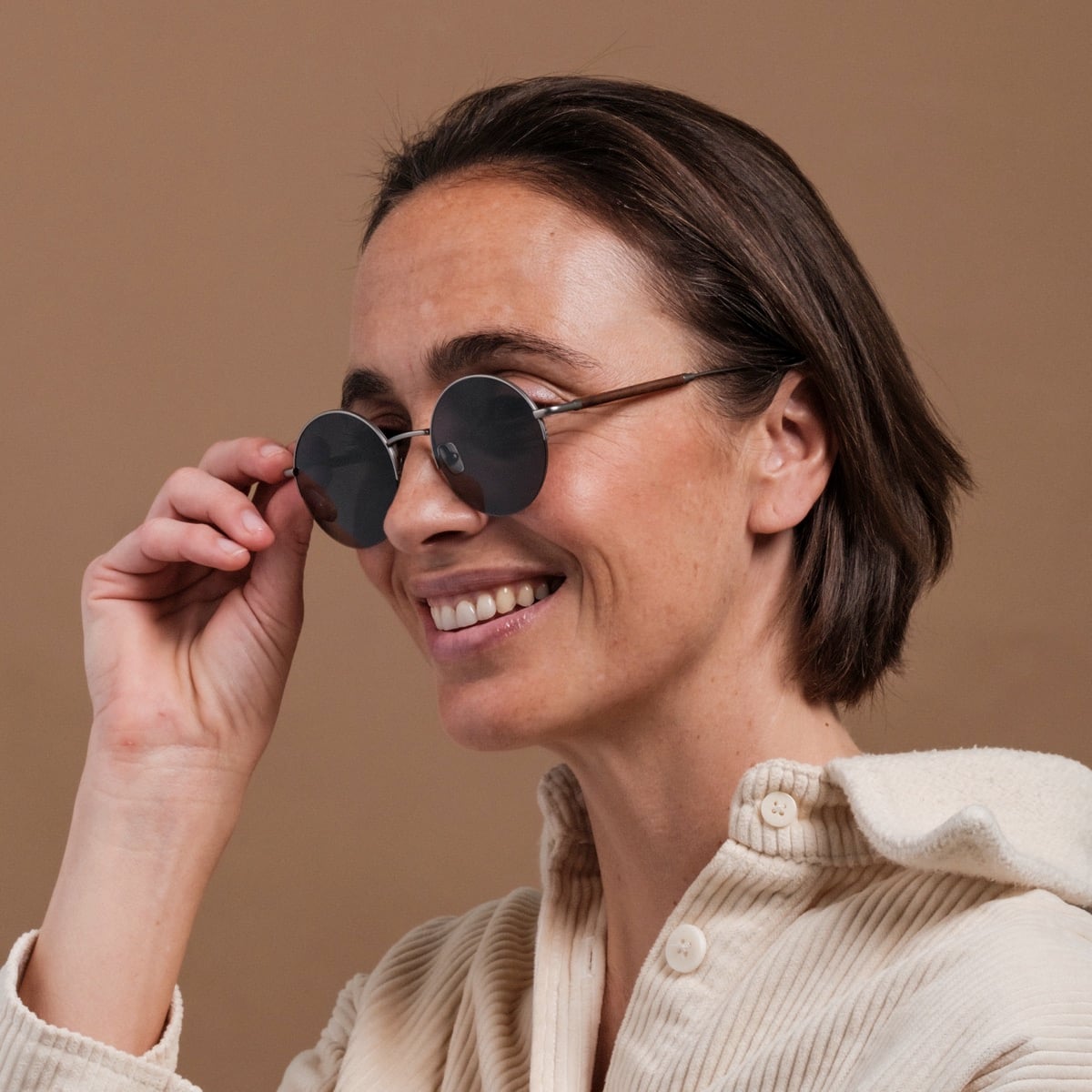 "The Adventurous" sunglasses featuring a walnut frame and dark gray lenses, embodying a sleek and modern style.